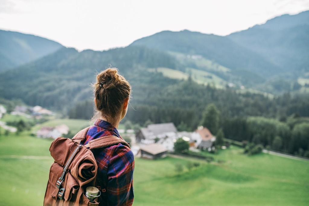 LassingFerienwohnungen Orth的一位带着背包的女人,看着群山