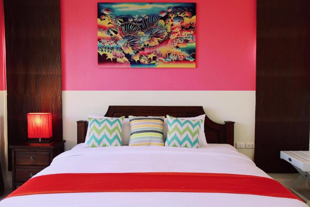 卡塔海滩OK Phuket的一间卧室配有一张带粉红色墙壁的大床