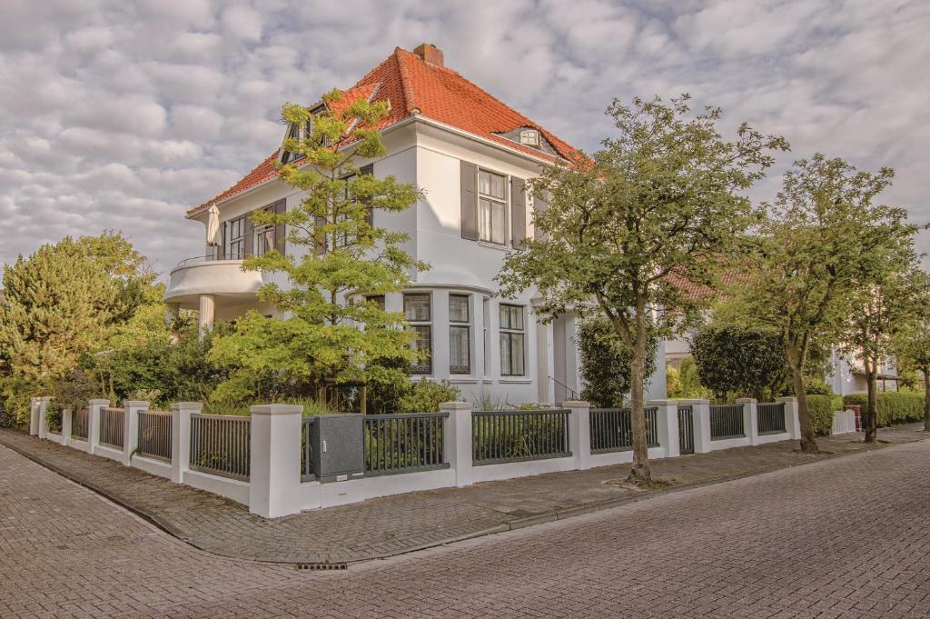 诺德奈Hotel Haus Norderney的前面有栅栏的白色房子