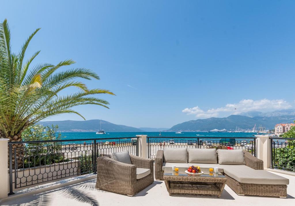 蒂瓦特Boka di Mare的一个带沙发和椅子的庭院和大海