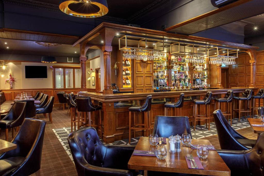 阿伯丁费里希尔酒店的一间带桌椅的餐厅和一间酒吧