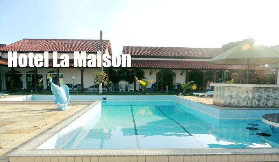 大伊瓜巴Pousada La Maison的大楼前设有游泳池的酒店
