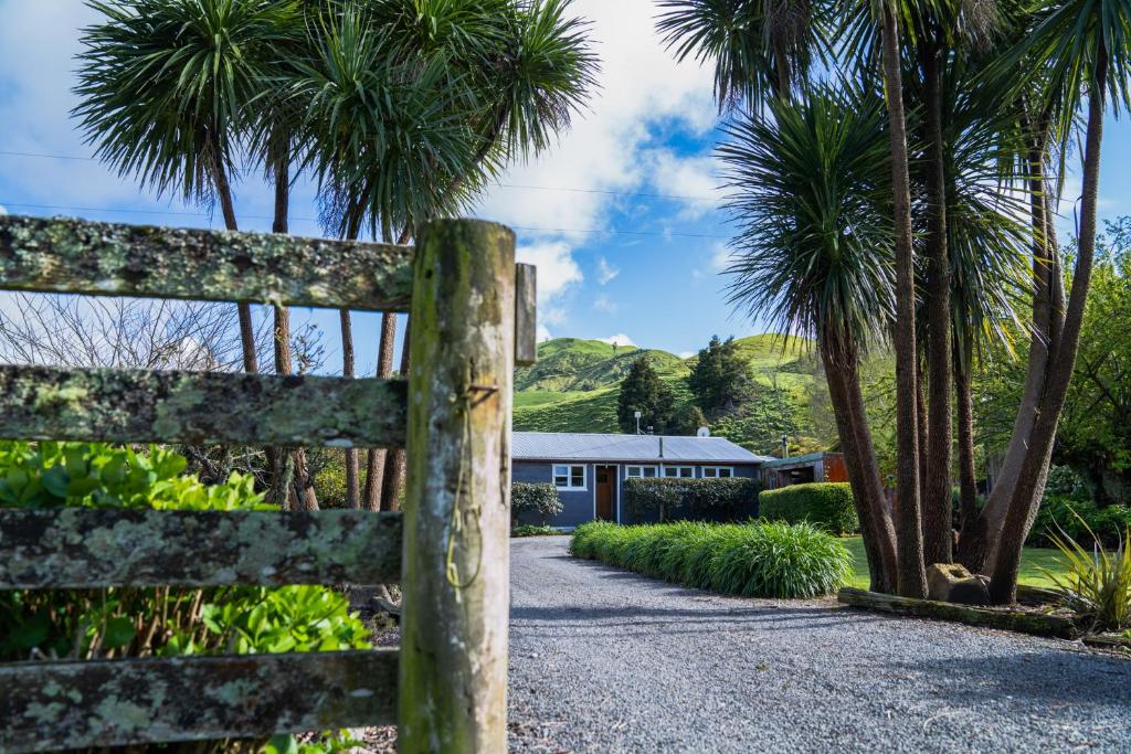 TinirotoMahaanui Cottage Farmstay的棕榈树屋前的围栏