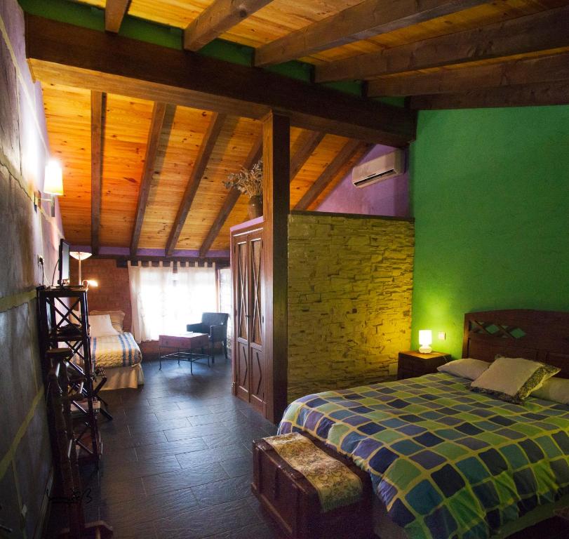 因凡特斯新镇La Casona del Abuelo Parra的一间卧室设有一张床和绿色的墙壁