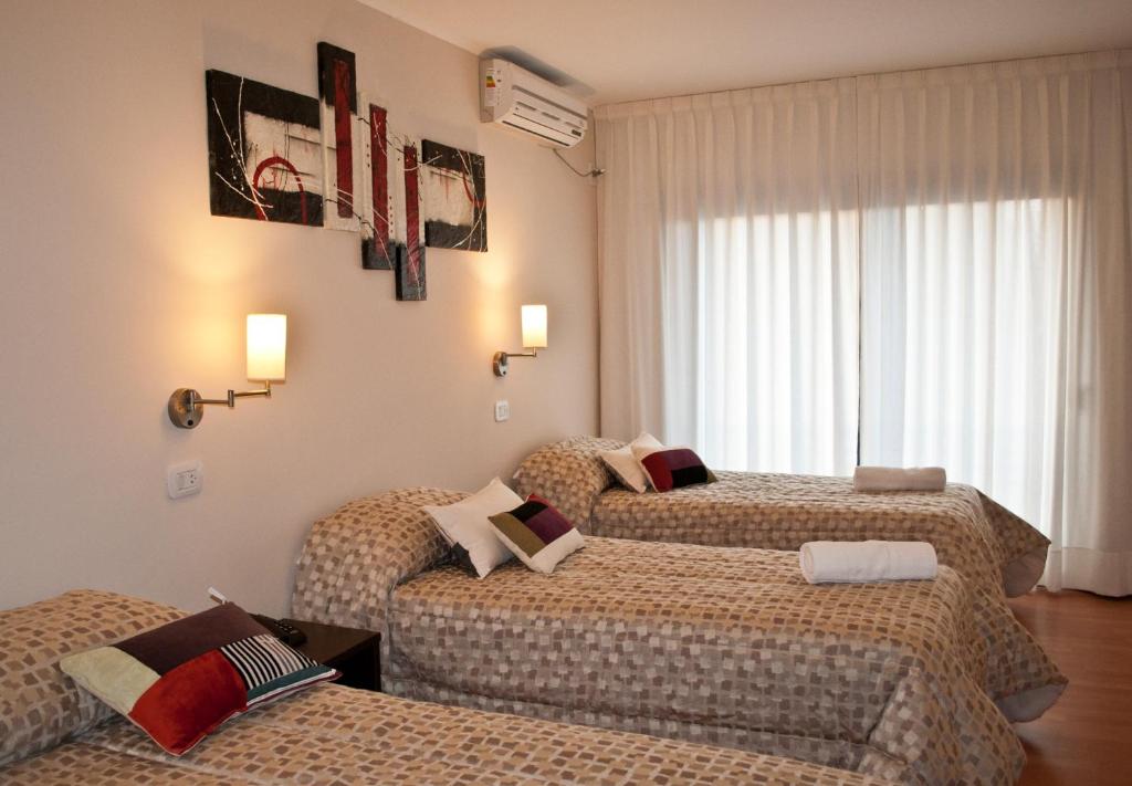 坦迪尔艾雷斯·坦迪尔酒店的酒店客房设有三张床和窗户。