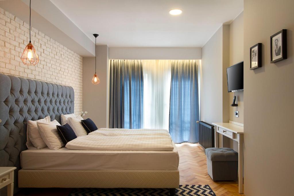 布加勒斯特Venis Boutique Hotel的一间卧室设有一张大床和一个窗户。