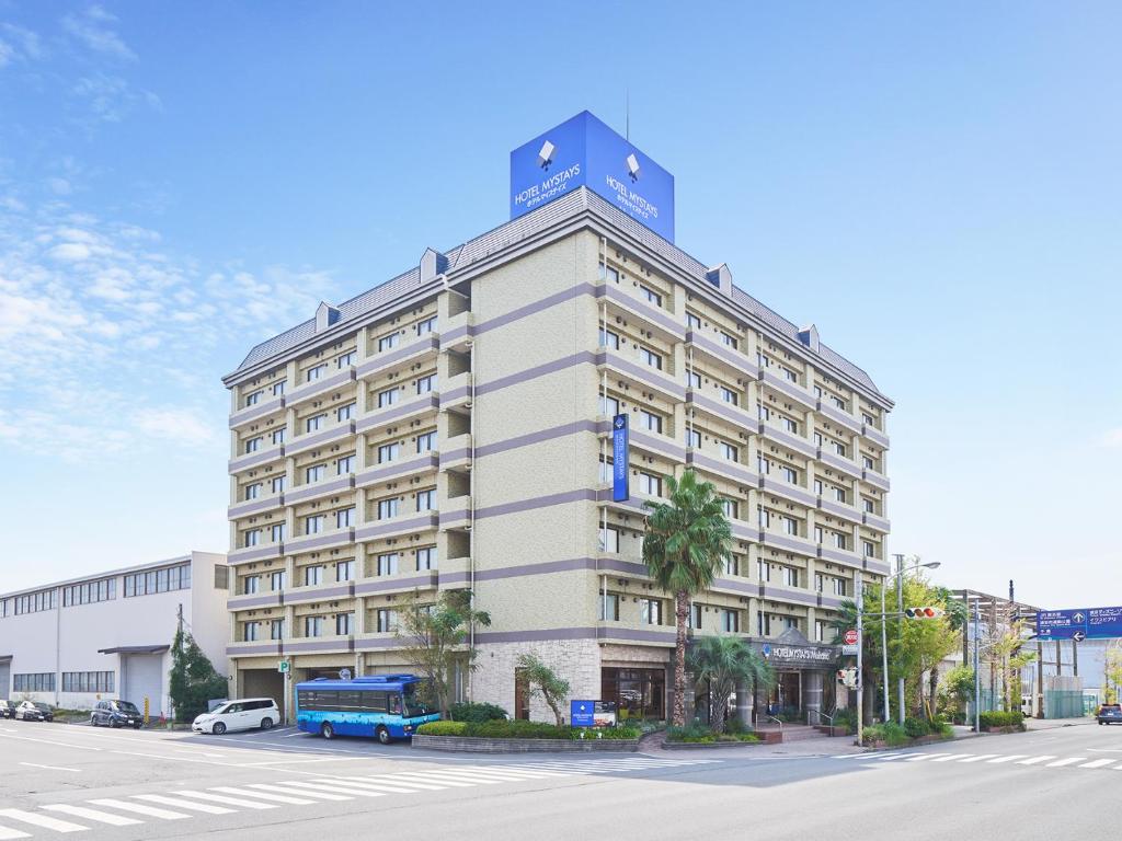 浦安MYSTAYS 舞滨酒店的一座白色的大建筑,上面有蓝色的标志