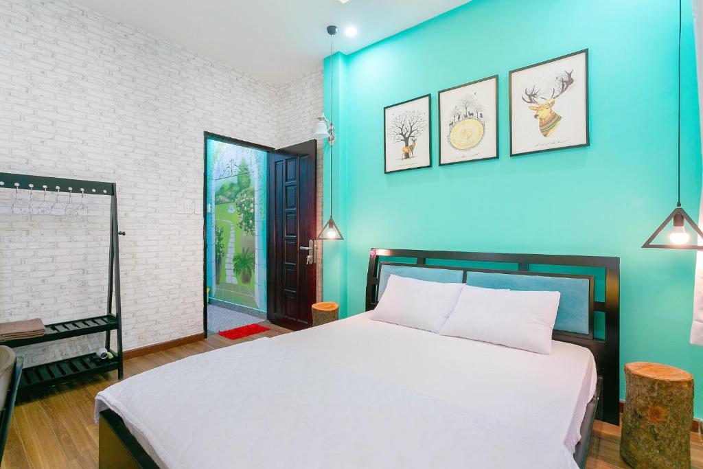 胡志明市Qcub3 Homestay的卧室配有白色的床和蓝色的墙壁