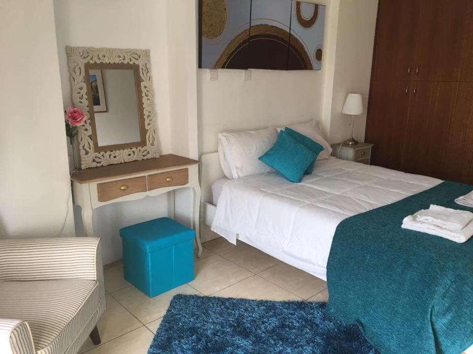 拉纳卡海滨211公寓式酒店的一间卧室配有床、镜子和凳子