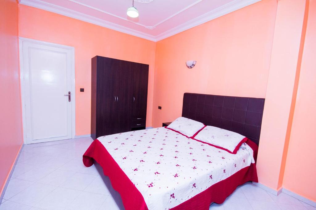纳祖尔Appart Hotel Wassila的一间卧室设有红色和橙色墙壁的床