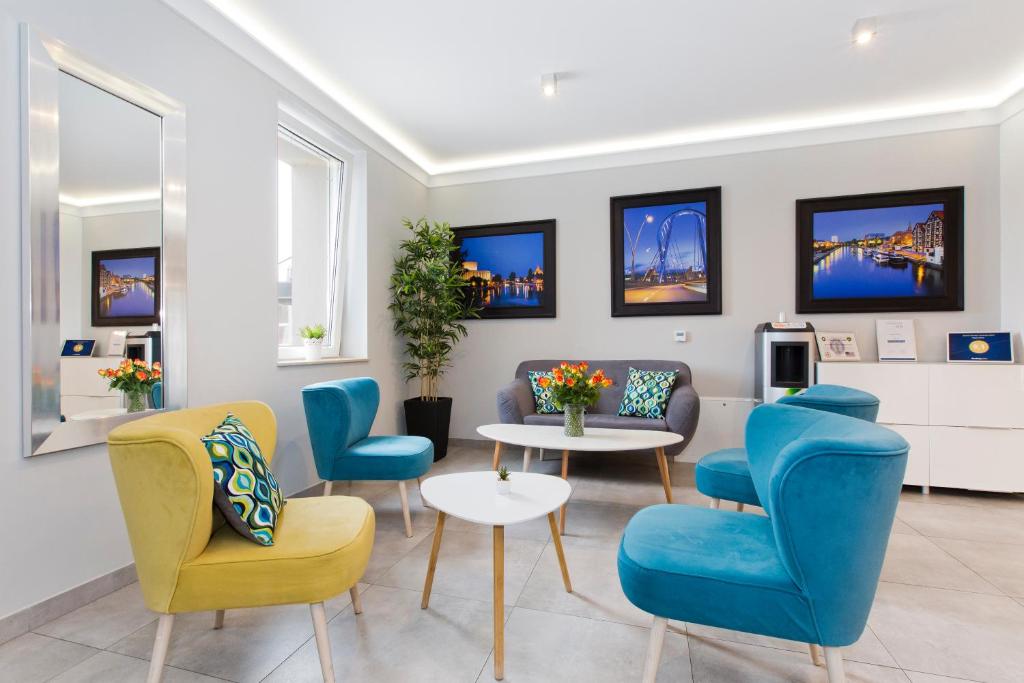 比得哥什希尔沃酒店的一间设有蓝色椅子和桌子的等候室