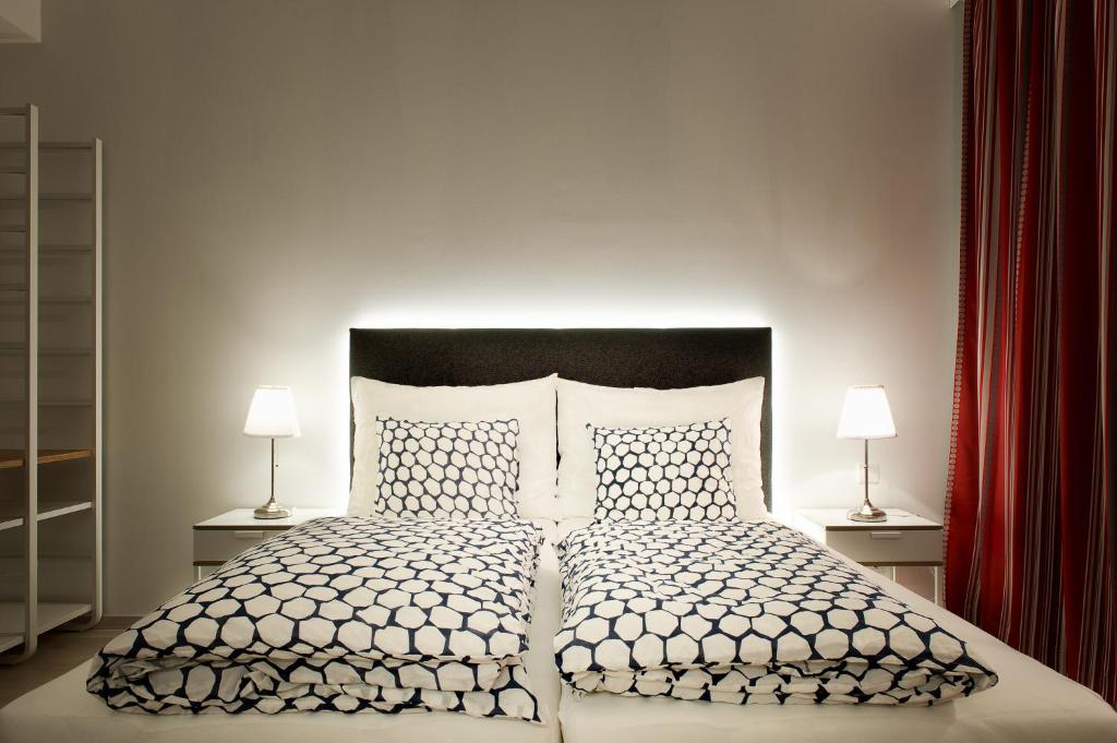 维也纳Pension am Wienfluss的一间卧室配有一张大床和两盏灯