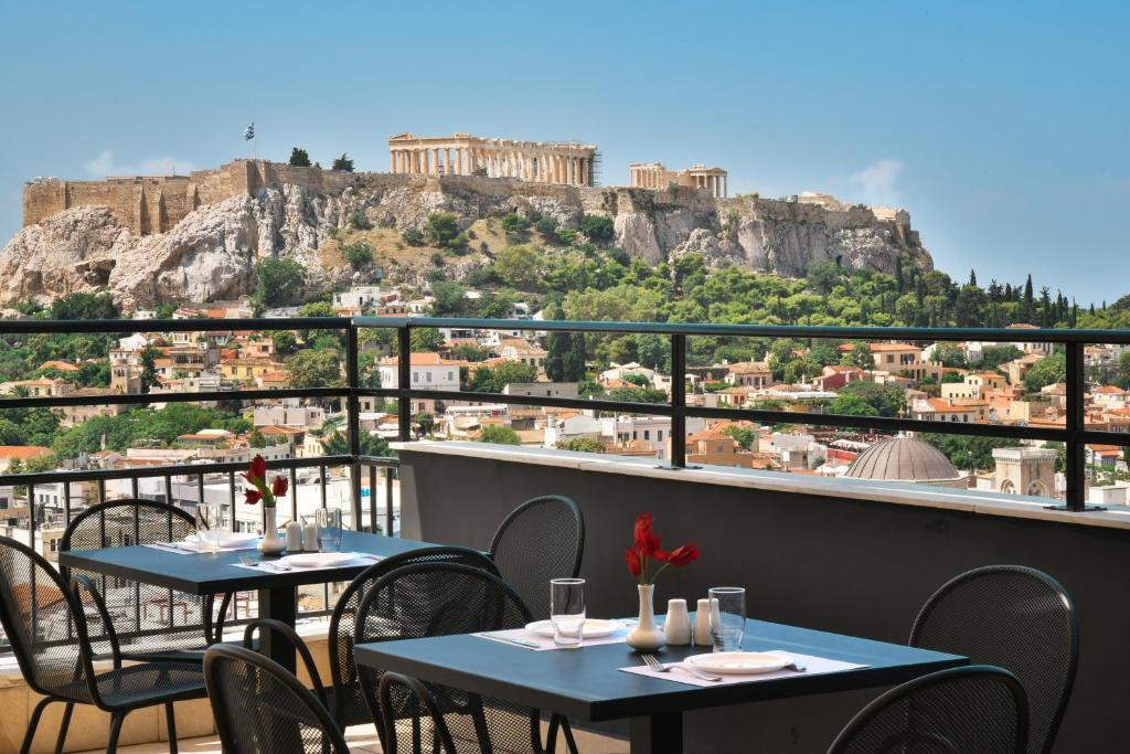 雅典Astor Hotel Athens的两个桌子,阳台享有雅典卫城的景色