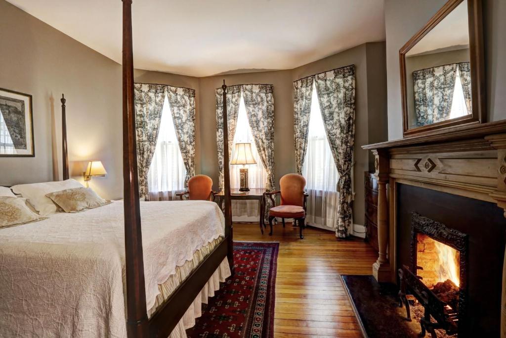 夏洛茨维尔200南大街旅馆的一间卧室配有一张床和一个壁炉
