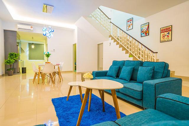 新山4-Bedrm ensuite family friendly house near Aeon Bukit Indah的客厅配有蓝色的沙发和桌子