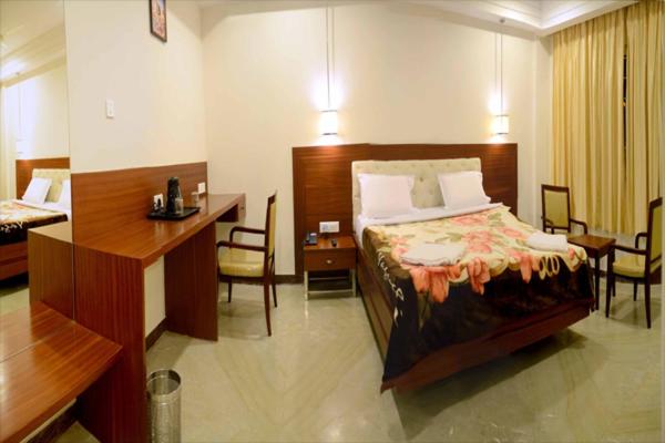 库姆巴科纳姆拉亚格兰德酒店的配有一张床和一张书桌的酒店客房