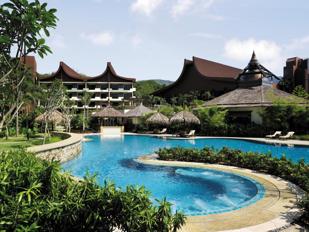 峇都丁宜槟城沙洋香格里拉的一座带大型游泳池的度假村,位于一座建筑前