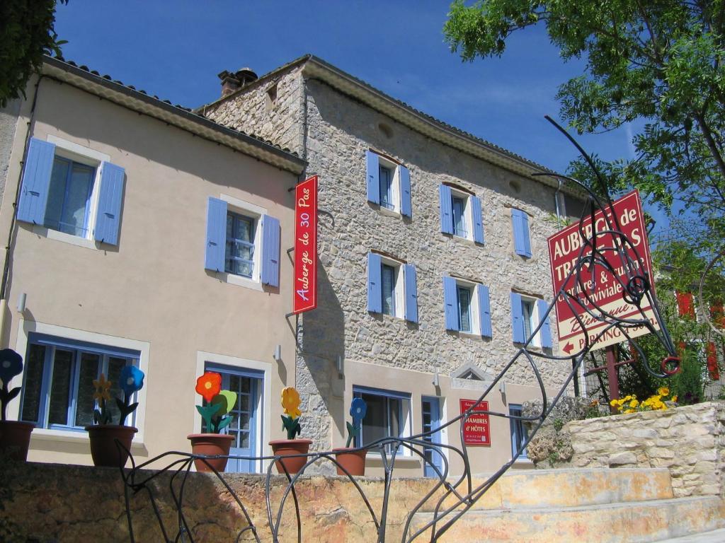 Saint-Ferréol-Trente-Pas特伦特帕斯住宿加早餐旅馆的前面有红色标志的建筑