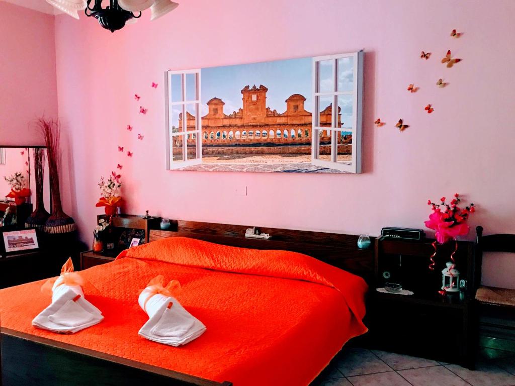 Leonforte24 Cannoli的粉红色的卧室配有红色床单和窗户