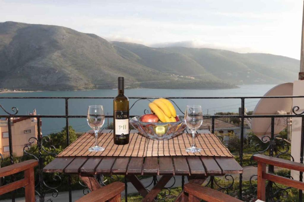 普拉塔里亚阿尔米尼公寓的一张桌子,上面放着一碗水果和一瓶葡萄酒