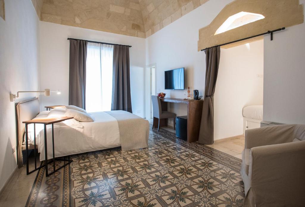 马泰拉Palazzo Montemurro的配有一张床和一张书桌的酒店客房