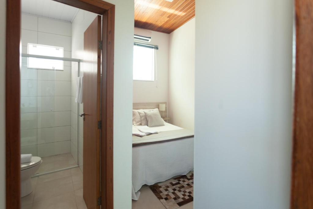弗洛里亚诺波利斯The Bridge Hostel Florianópolis的一间带一张床、淋浴和卫生间的浴室