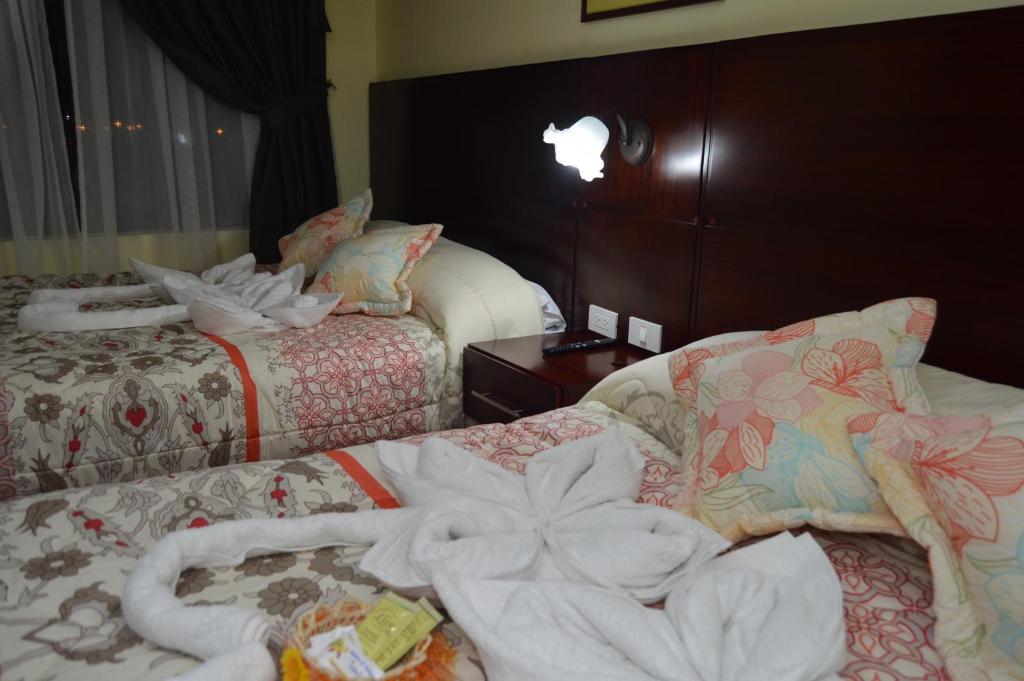 拉塔昆加Balcones del Río Hotel的酒店客房,配有两张带毛巾的床