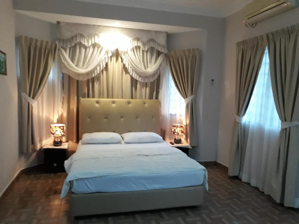 双溪大年SMART Homestay Permaipura的一间卧室设有一张大床和两个窗户。