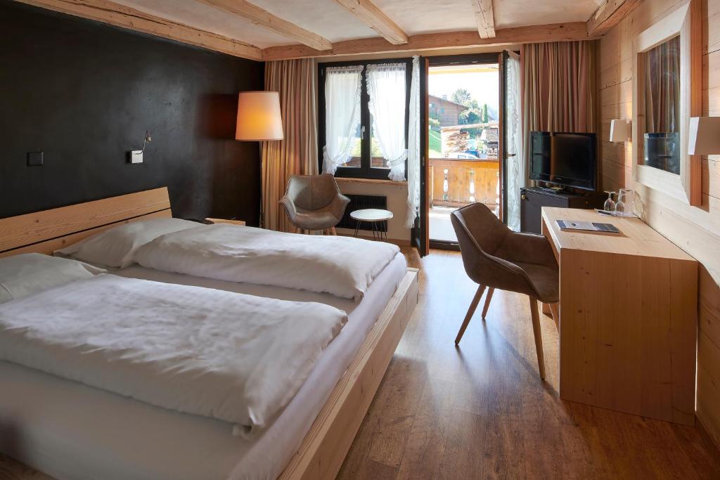 格施塔德奥尔夫恩酒店的一间卧室配有两张床、一张桌子和一台电视。