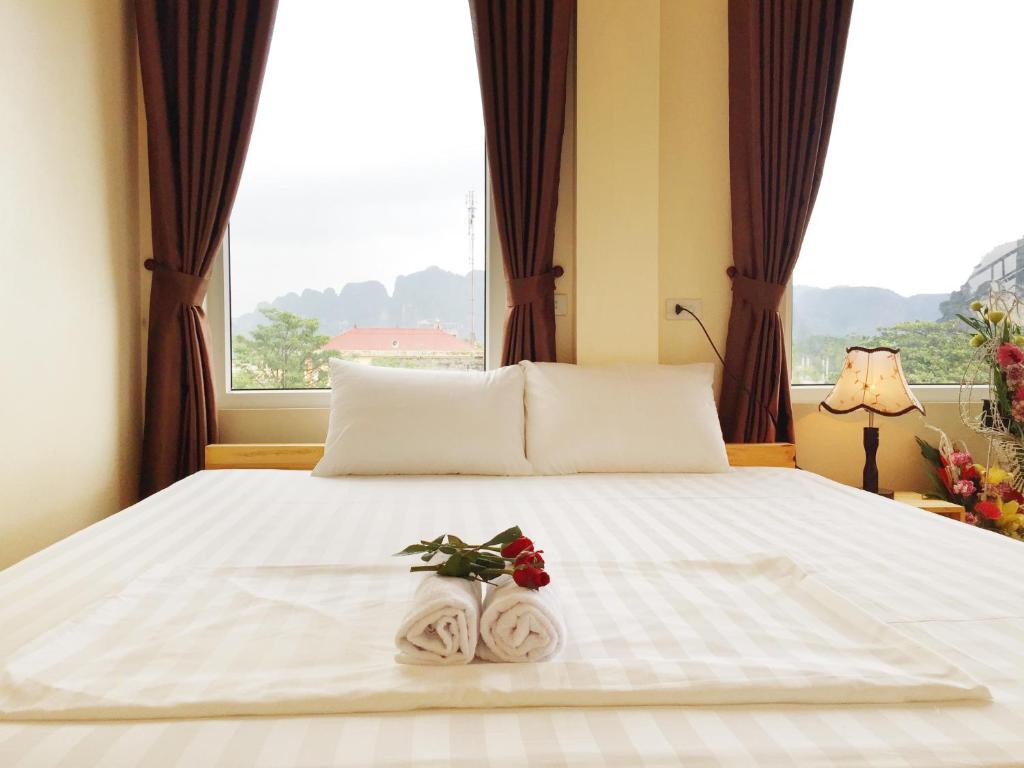 宁平Ha Lan Homestay的一间卧室配有带毛巾的床和窗户。