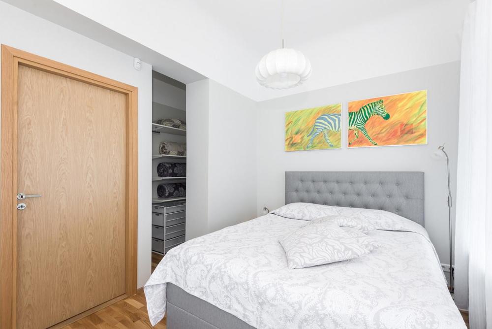 派尔努Kuninga City Center Apartment的一间白色卧室,配有一张床和一个衣柜