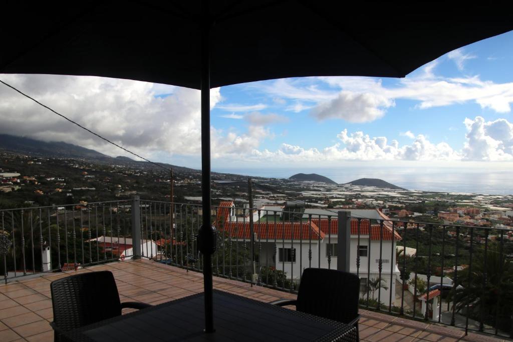 洛斯·亚诺斯·德·阿里丹Casa Clotilde的阳台顶部带雨伞的桌子