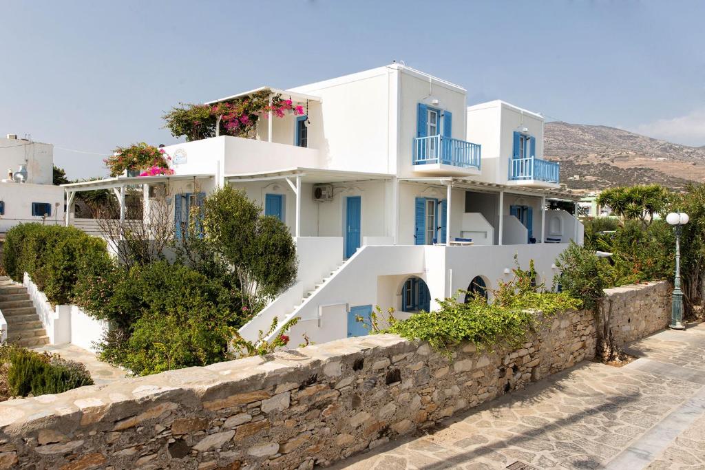 德里奥斯塔萨公寓酒店的白色的房子,设有蓝色的窗户和石墙