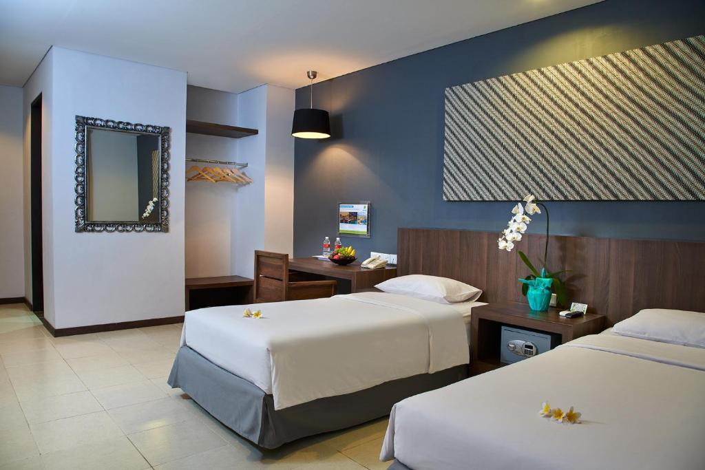 登巴萨普拉亚酒店的酒店客房,设有两张床和镜子