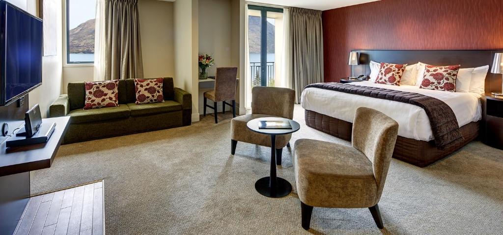 皇后镇Rendezvous Heritage Hotel Queenstown的一间配有床、沙发和桌子的酒店房间