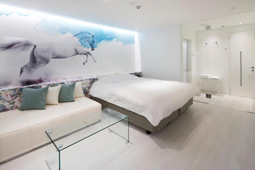 花卷市HOTEL LYISTA (Adult Only)的一间卧室配有床、沙发和绘画