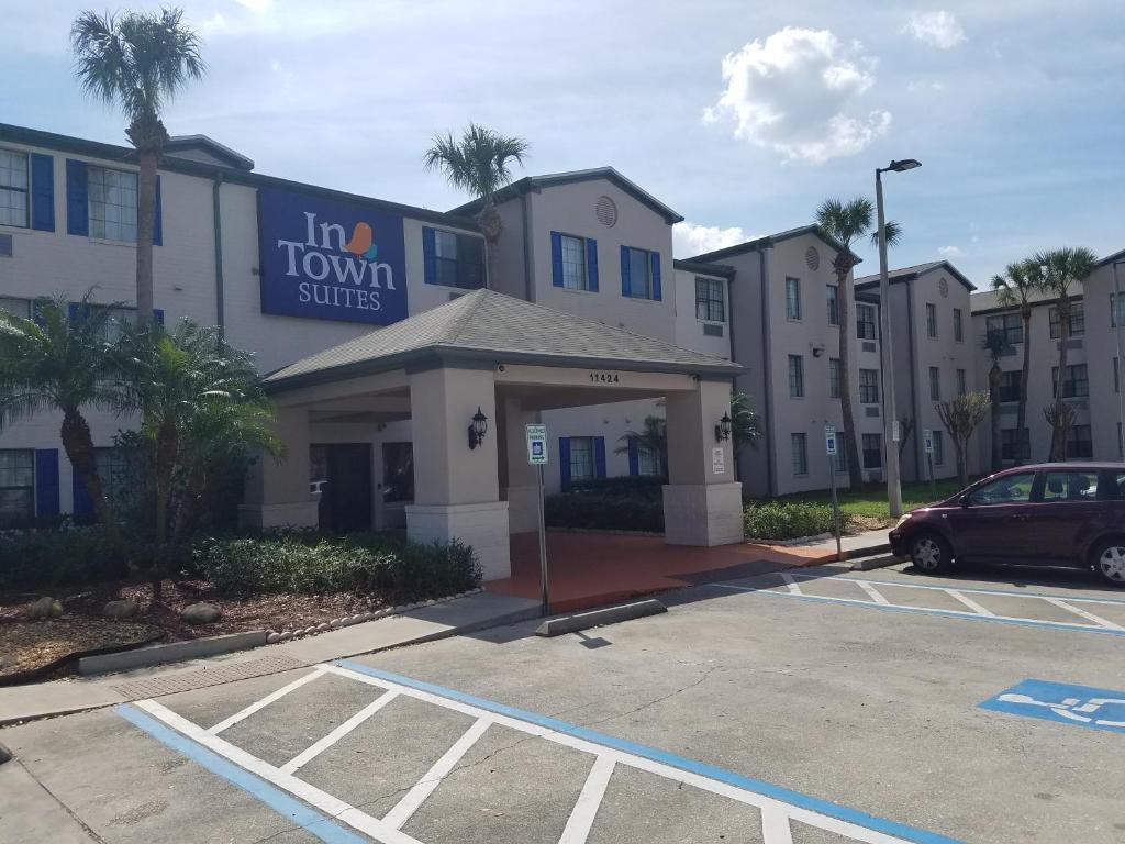 奥兰多InTown Suites Extended Stay Select Orlando FL - UCF的停车场内有停车位的建筑物