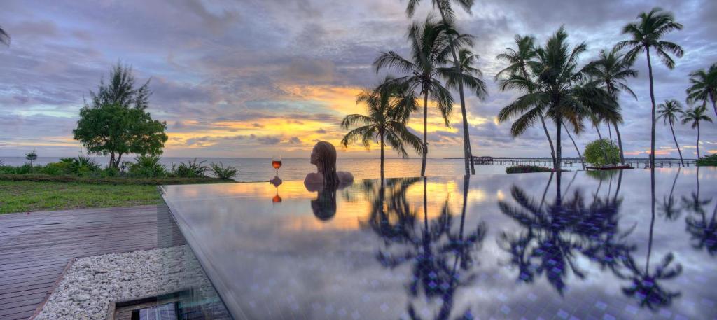 基济姆卡济桑给巴尔住宅酒店的享有棕榈树泳池和日落美景