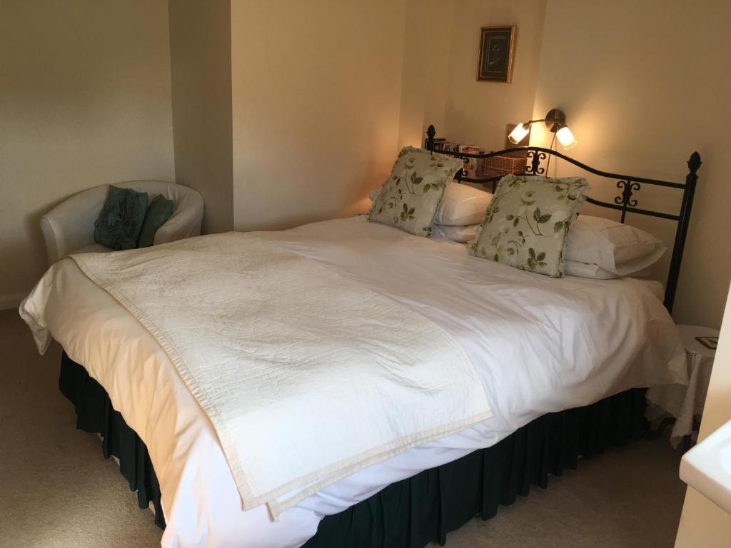 Newbold on StourThe Poplars的一间卧室配有带白色床单和枕头的床。