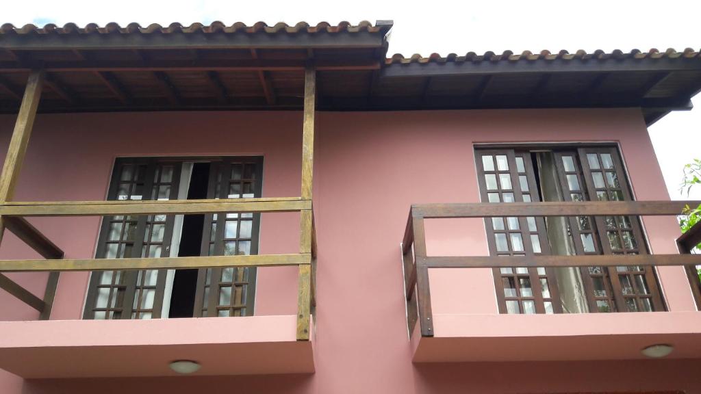 弗洛里亚诺波利斯Pousada Barra da Lagoa的粉红色房子一侧的两扇窗户