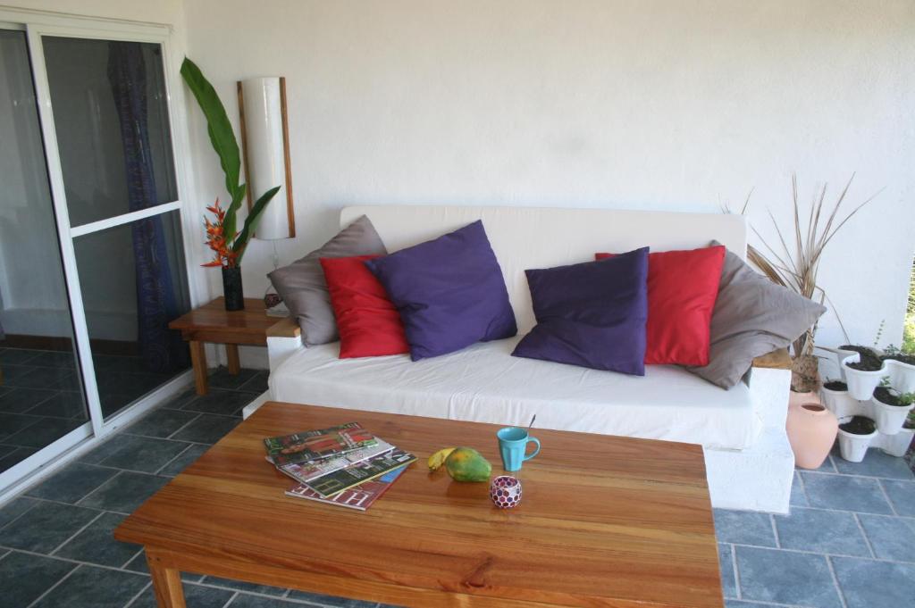 Tevaitoaocéan studio的客厅配有带色彩缤纷枕头的白色沙发