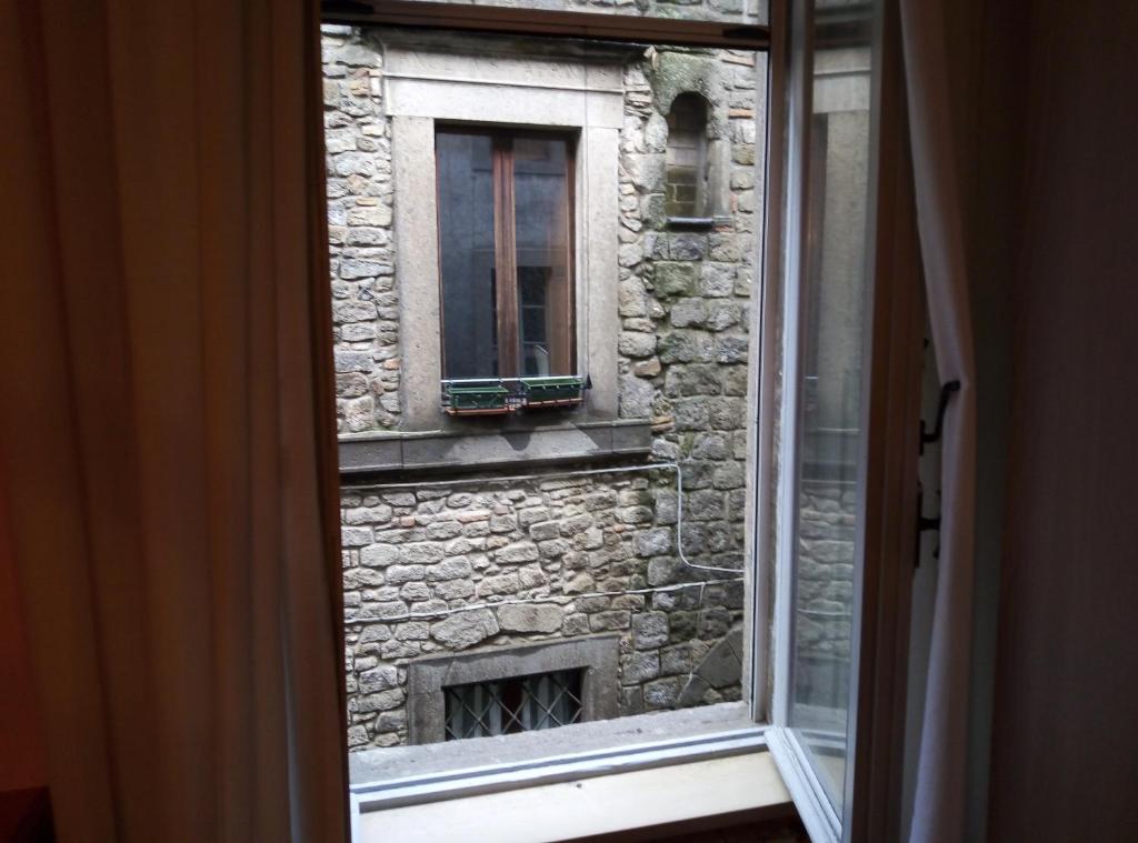维泰博casa medioevo的享有石头建筑的窗户和壁炉的景色