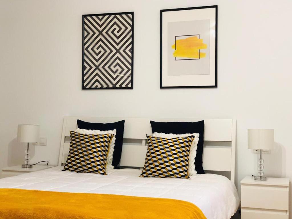 纳萨雷特Canaryislandshost l Lovely Lanzarote的一间卧室配有一张带两盏灯和两张照片的床。
