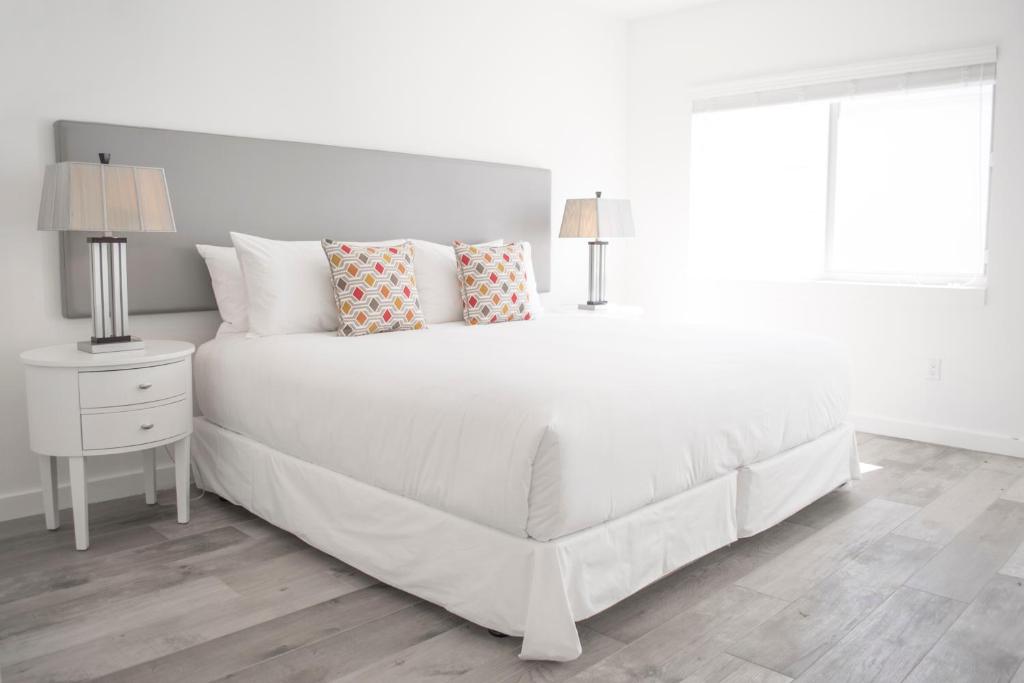迈阿密海滩Sobe Lux的白色卧室配有白色的床和枕头
