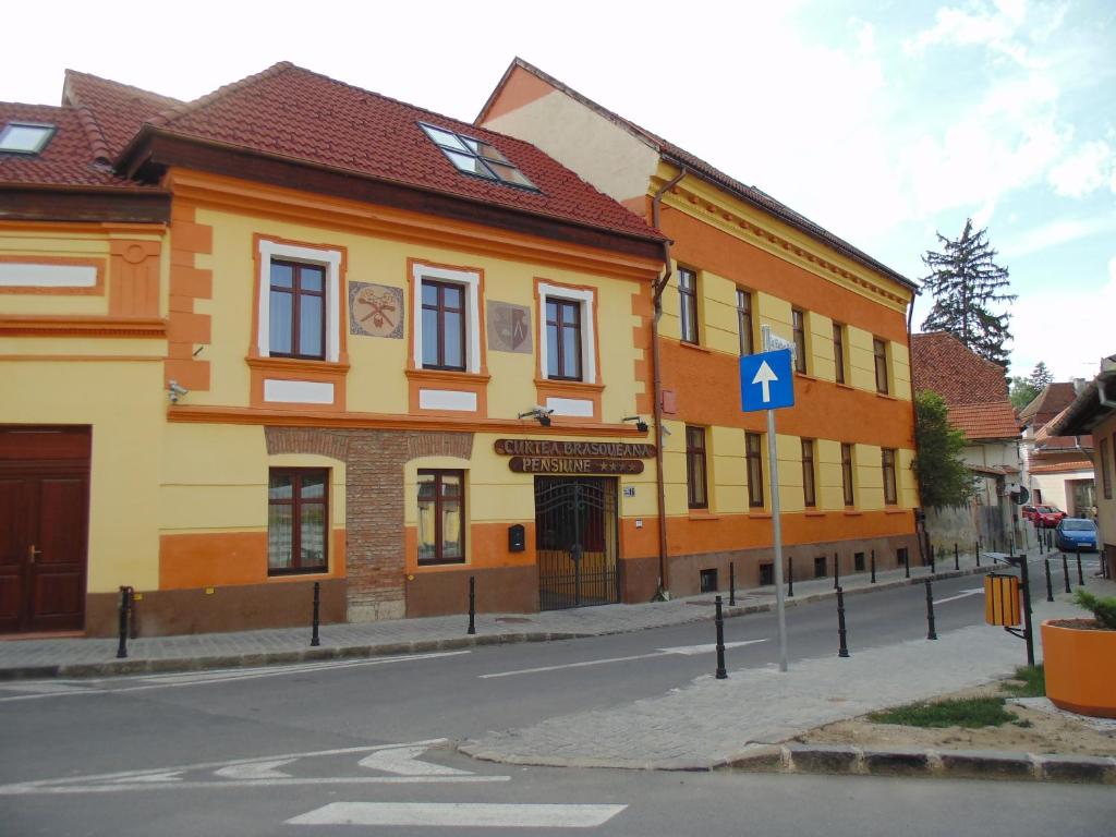 布拉索夫布拉索夫庭院酒店的街道边的黄色和橙色建筑
