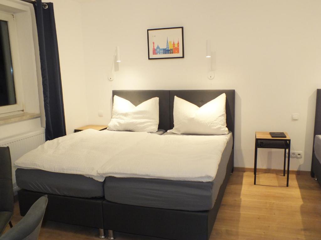 林茨Apartments at Winterhafen的一间卧室配有带白色床单和枕头的床。