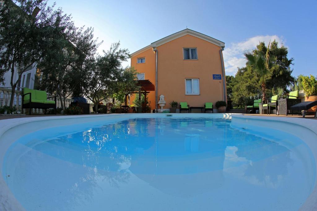 扎达尔朱利安别墅酒店的一座大蓝色游泳池,位于房子前