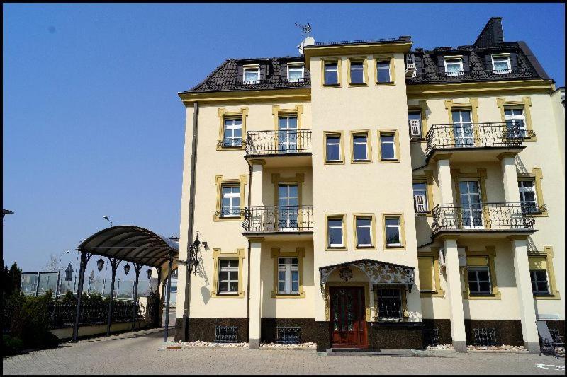 奥普尔扎德泽酒店的一座黄色的大建筑,前面有一个门