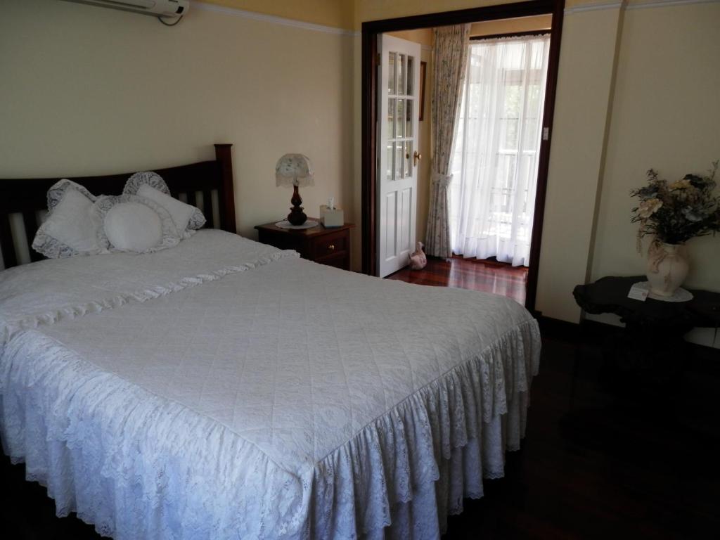 阿马代尔奢华隐居住宿加早餐旅馆的卧室配有带白色棉被的床