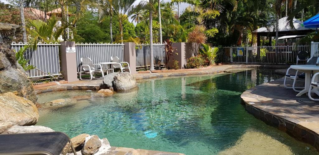 凯恩斯礁棕榈酒店的一个带桌椅的水池